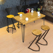 Load image into Gallery viewer, Dining area with a wooden table featuring 28-inch matte black 3-rod hairpin table legs, surrounded by stylish bar stools.