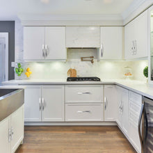 Load image into Gallery viewer, Modern kitchen with brushed satin nickel arch drawer pulls on white cabinets and a sleek countertop setup.